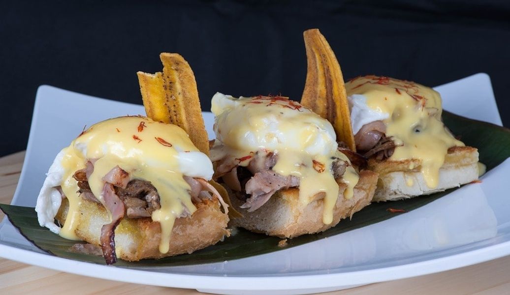 Breakfast sandwiches on a white plate with ham eggs and cheese cheap food in Cuba