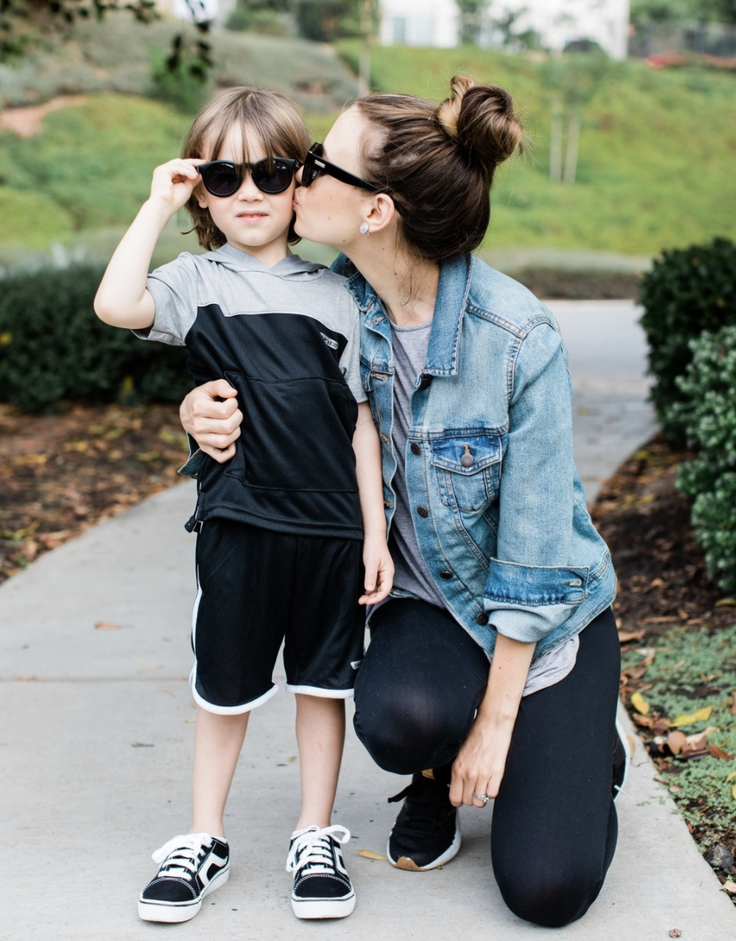 Boy in kidpik clothes being kissed by mom 