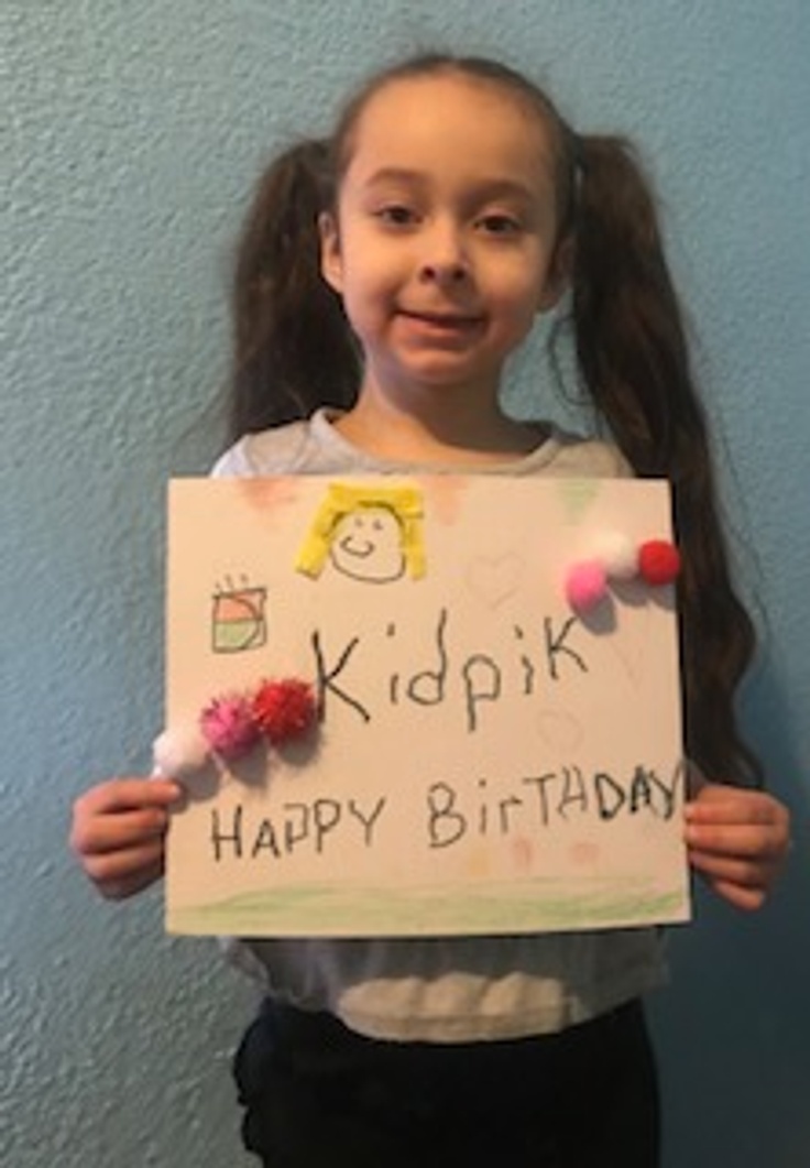 Girl holding happy birthday kidpik card