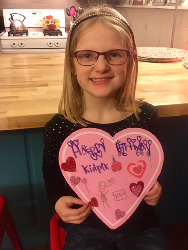 Girl holding happy birthday kidpik card