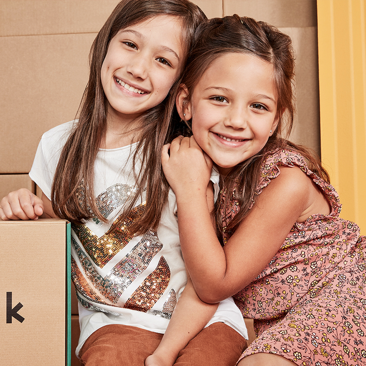 Two girls next to kidpik clothing subscription box