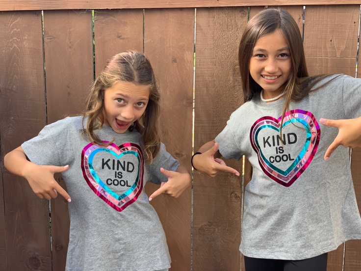 Girls pointing at their kindness shirts