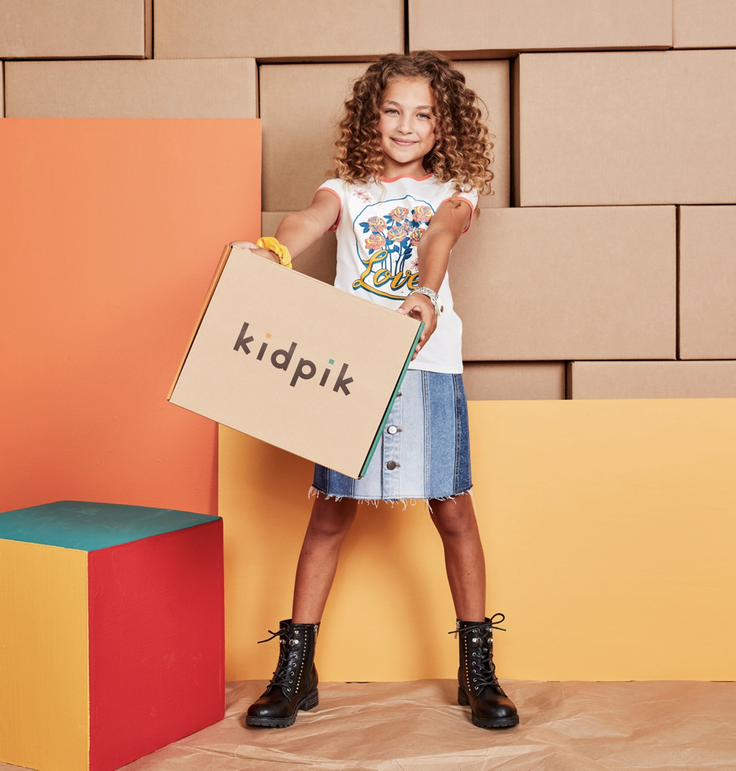 Girl holding kidpik fashion subscription box